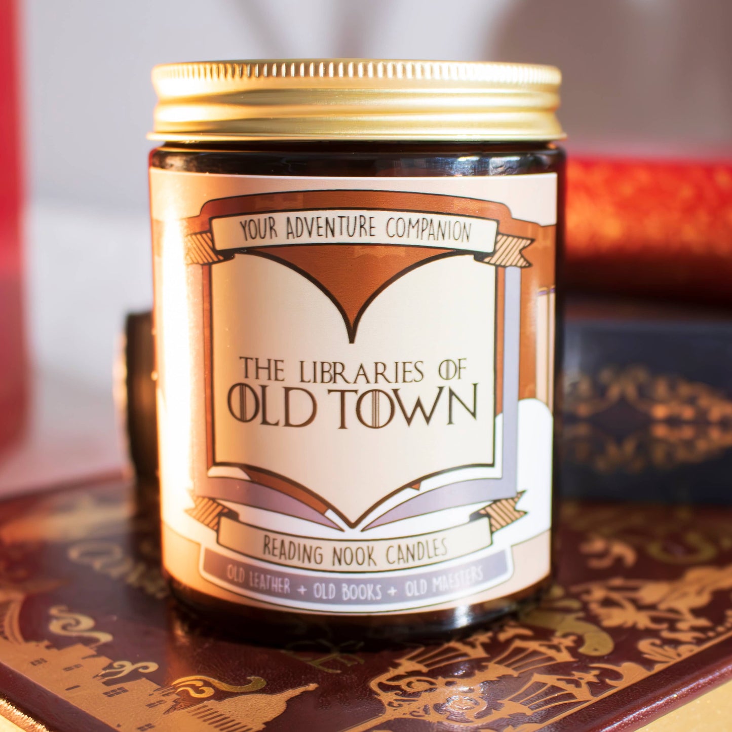 Candle with a decorative label on a surface saying Libraries of Old Town Candle