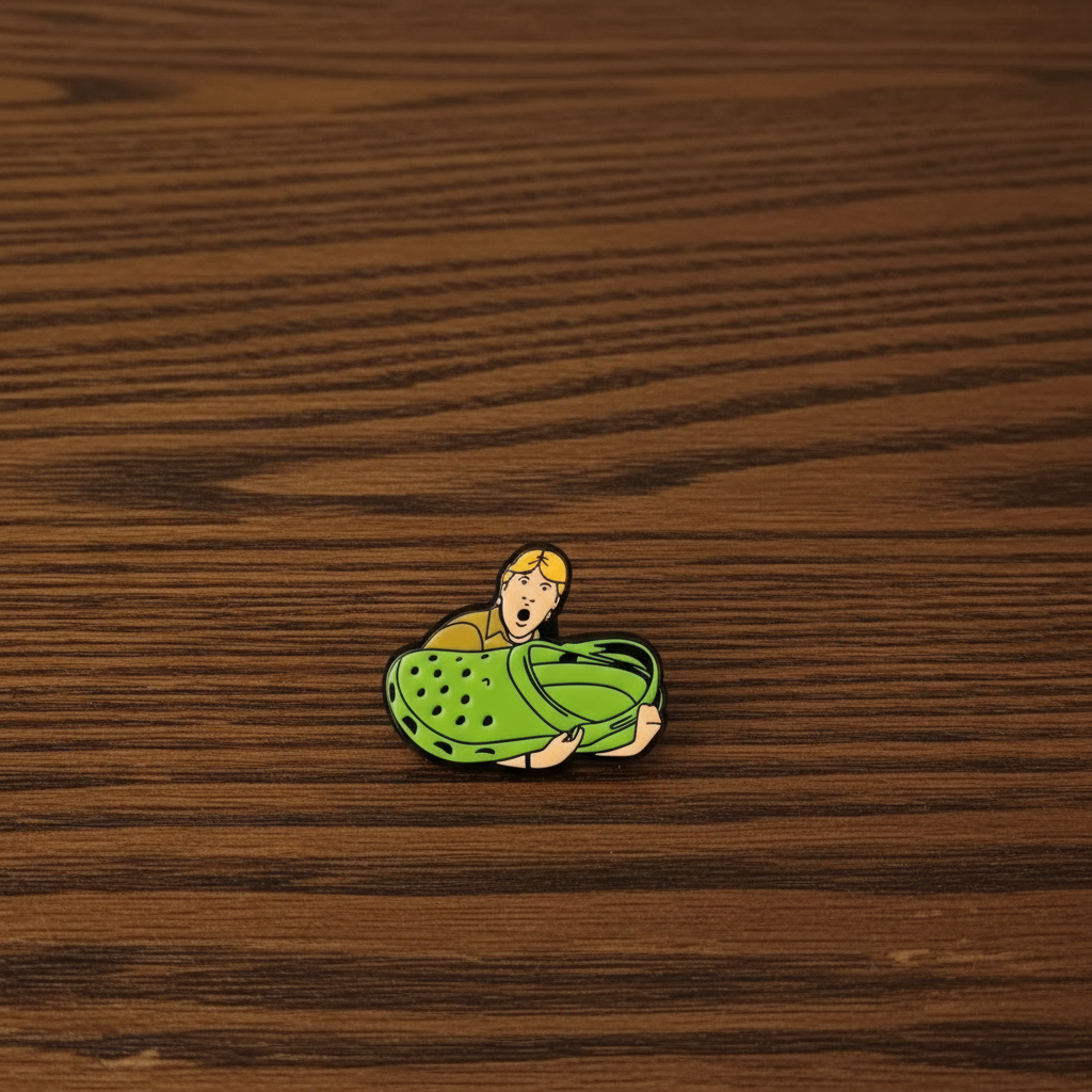Enamel Pin of Steve Irwin Holding a Croc Shoe on a dark oak table.