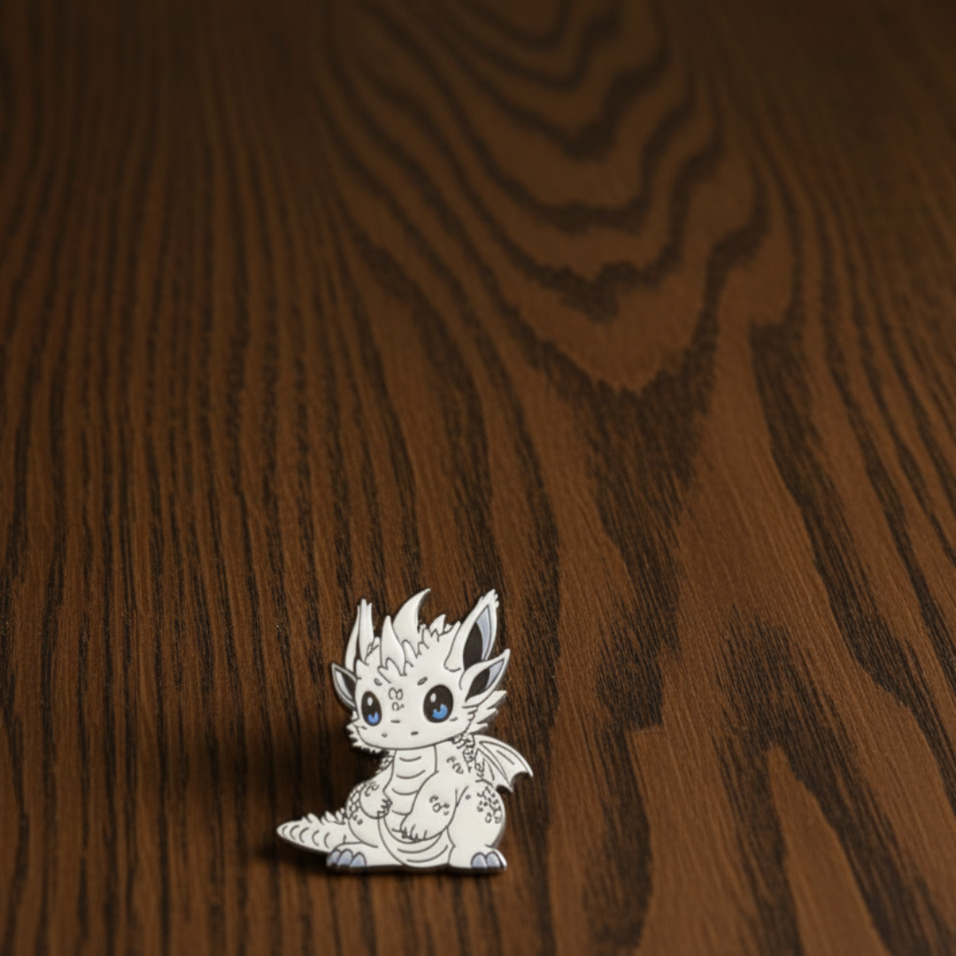 White Pointy Ear Dragon Pin Badge on a dark oak table