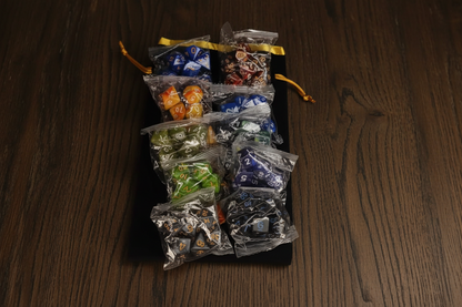 Assorted polyhedral dice in clear bags on a dark background