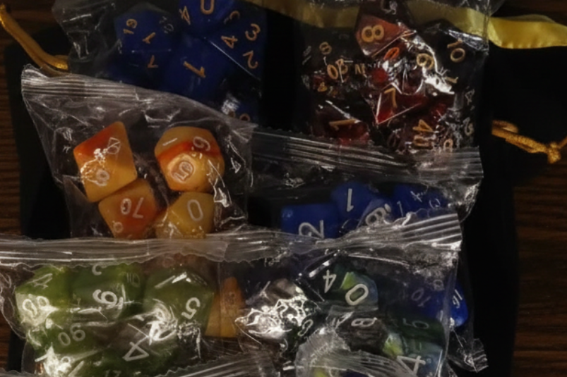 Assorted polyhedral dice in clear packaging on a dark background