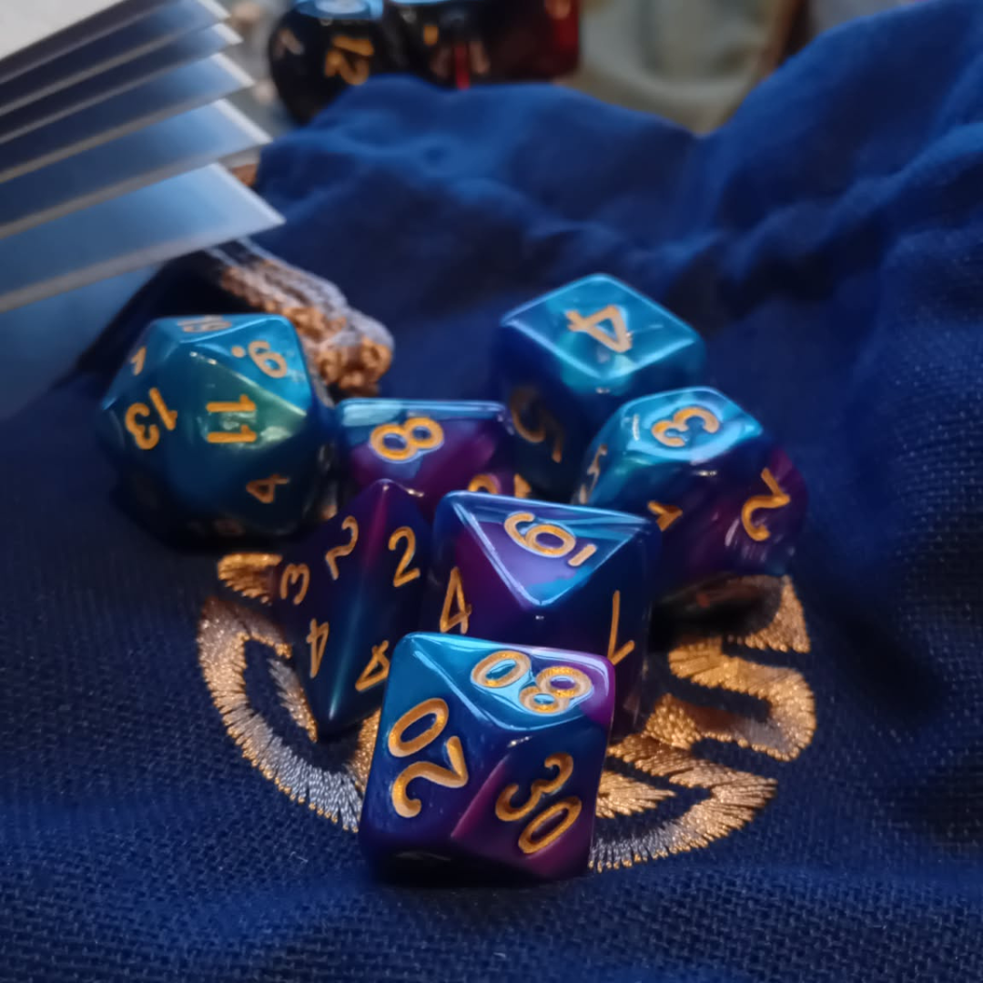 Set of polyhedral dice with blue and purple colors on a textured surface
