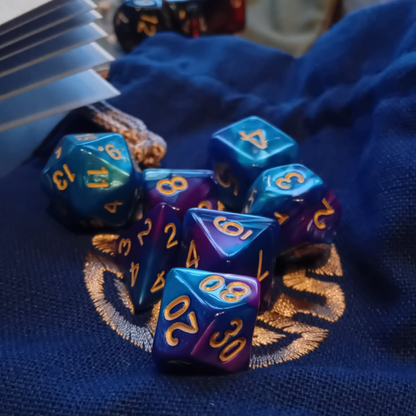 Set of polyhedral dice with blue and purple colors on a textured surface