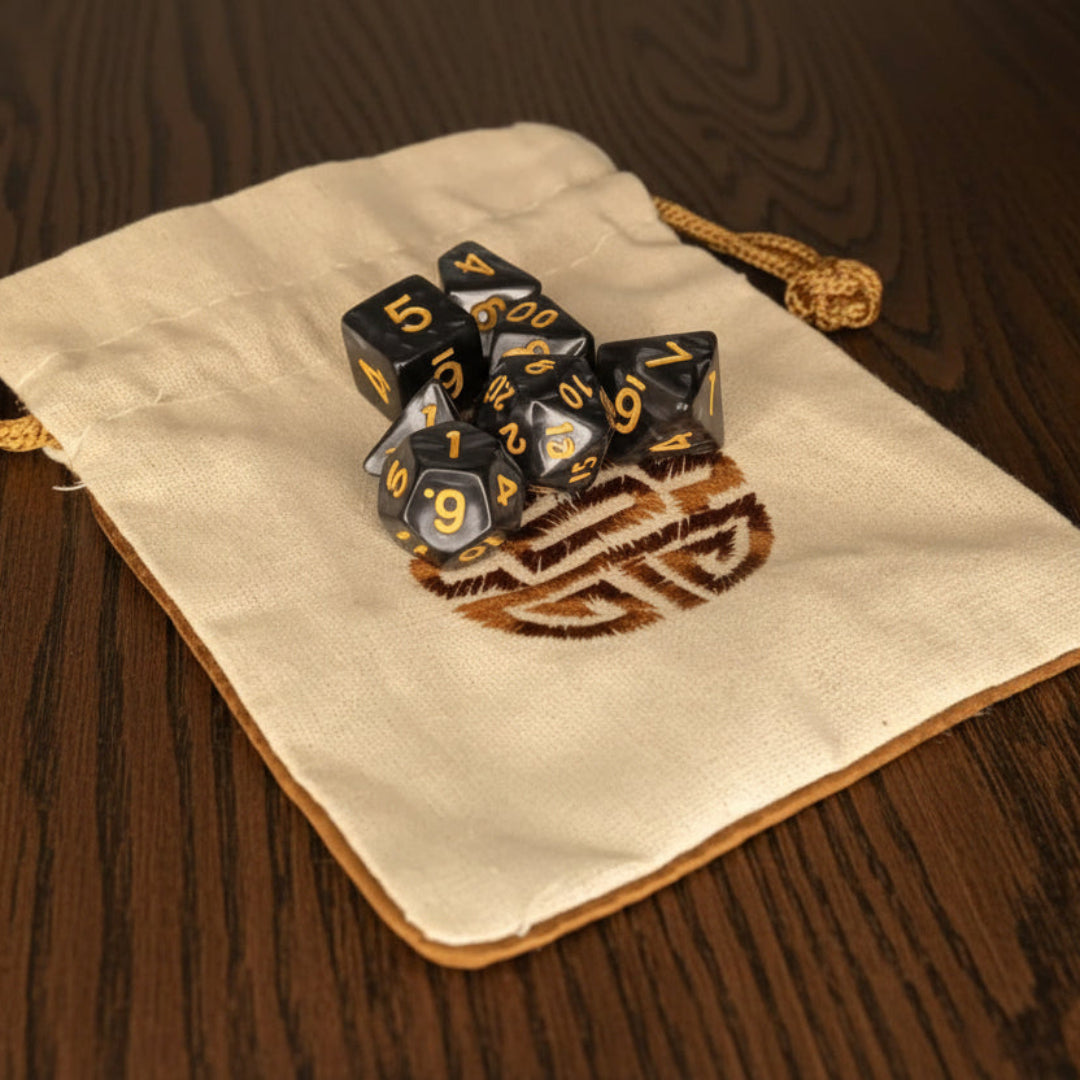 Set of dice with blue and gold design on a beige drawstring bag against a dark oak table
