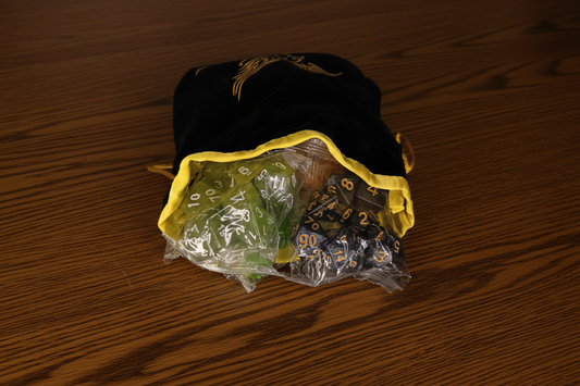 Set of 10 polyhedral dice with green and black colors in a yellow bag.