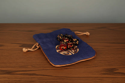 Blue drawstring pouch with dice design on a dark oak table