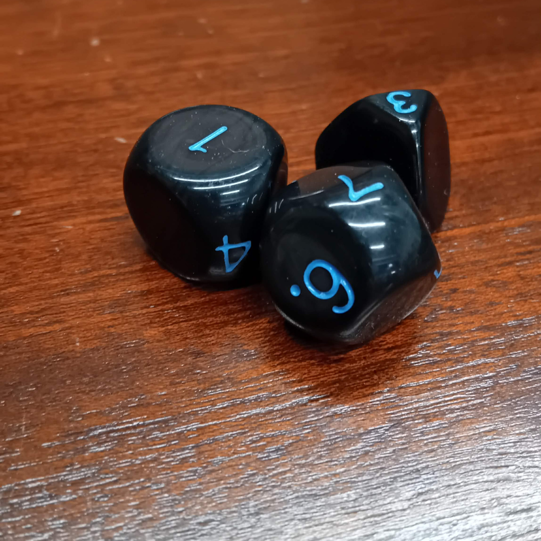 Black dice with blue numbers on a wooden surface