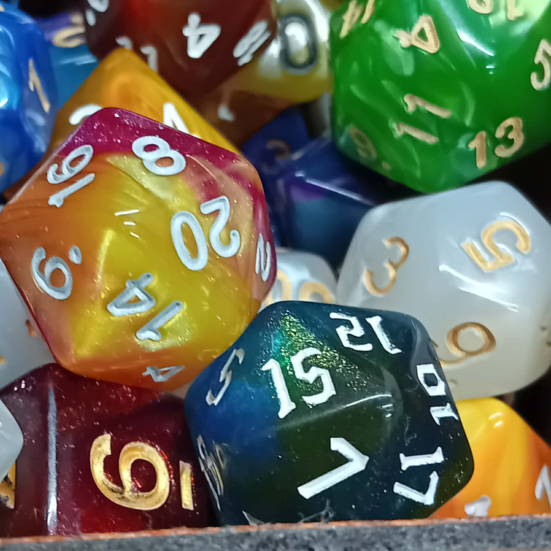 Close-up of multicolored polyhedral dice with numbers on a textured surface.