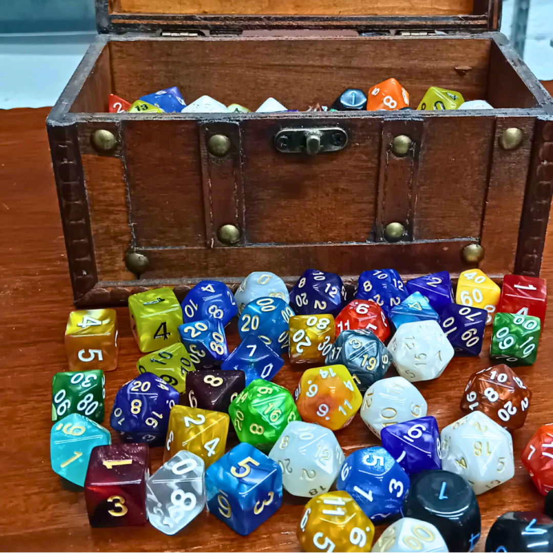 Wooden chest filled with multicolored dice on a wooden surface