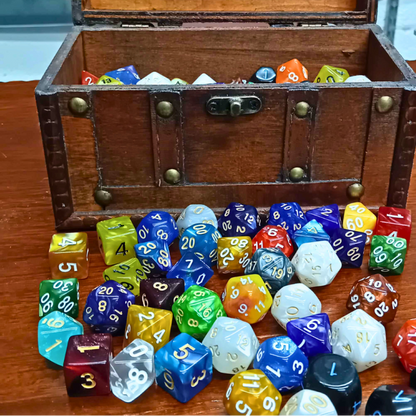 Wooden chest filled with multicolored dice on a wooden surface