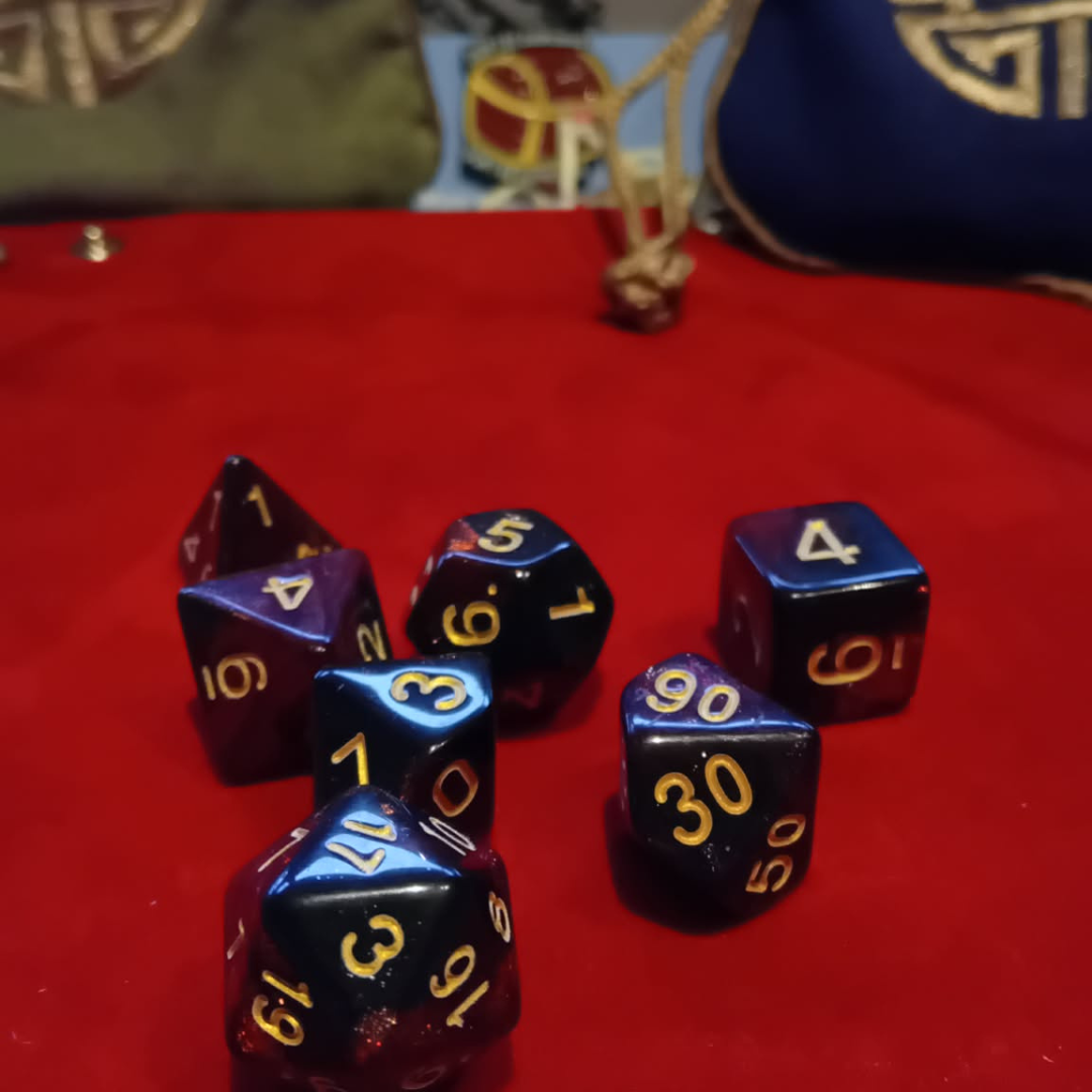 Set of blue and purple polyhedral dice with gold numbers on a red surface.