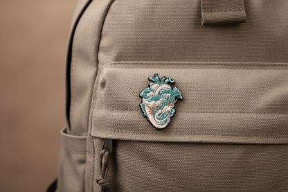 A heart shaped blue and white dragon on a backpack