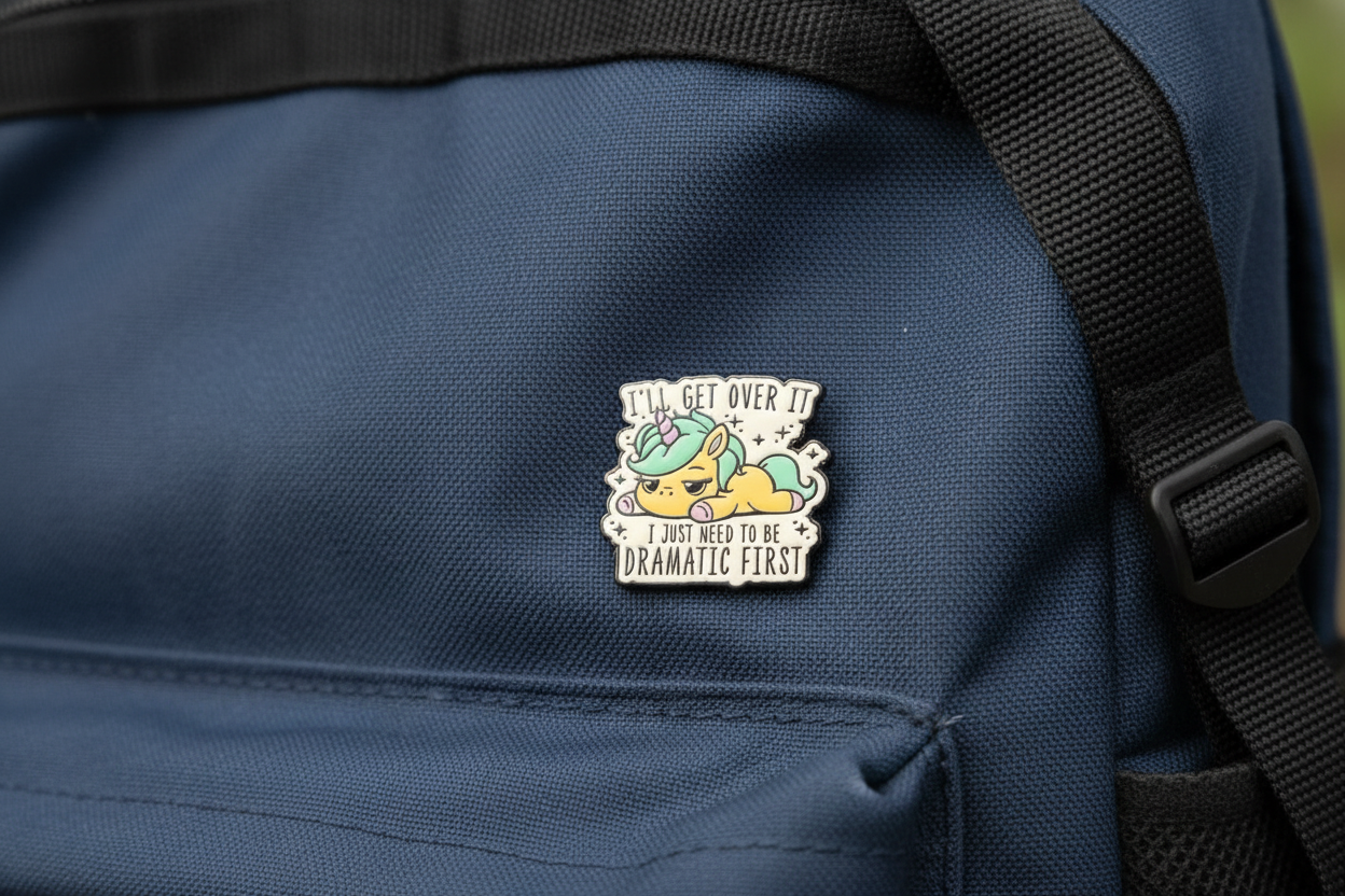 Pin with a cartoon Unicorn on that says I'll get over it, I just need to be Dramatic First on a backpack