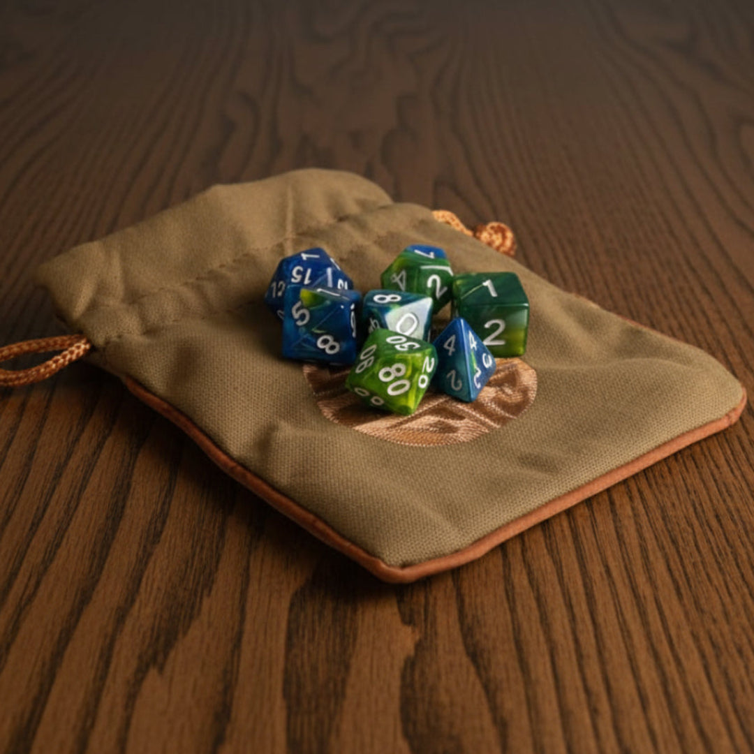 Green drawstring bag with polyhedral dice on a dark oak table