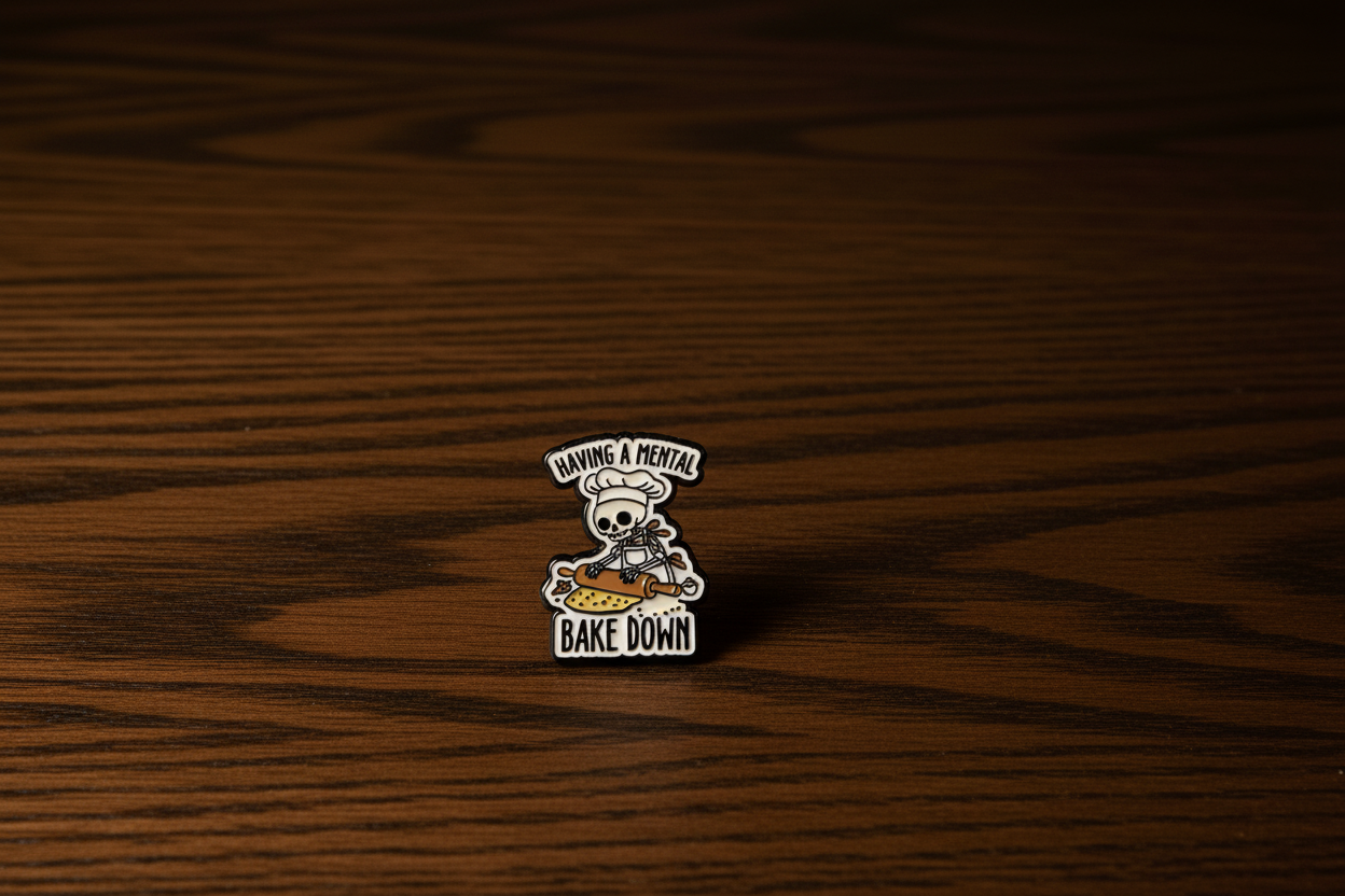Pin Badge with a skull chef design on saying having a mental back down on a dark oak table