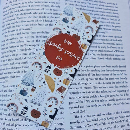 Decorative bookmark with Halloween-themed illustrations on an open book
