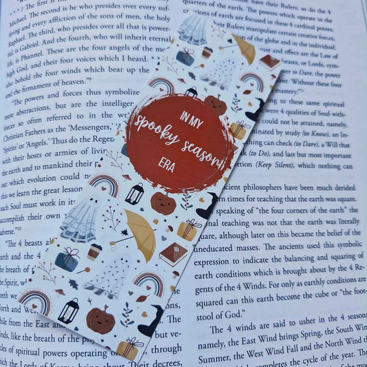 Decorative bookmark with Halloween-themed illustrations on an open book