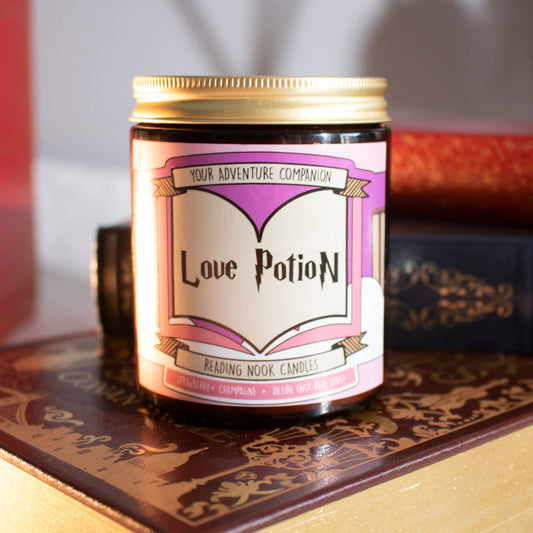 Candle labeled 'Love Potion' with decorative text on a patterned surface