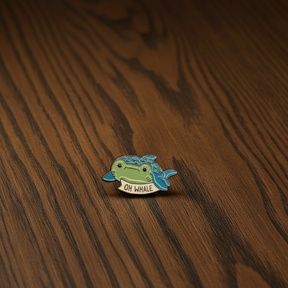 Small whale-shaped pin badge on a dark oak table