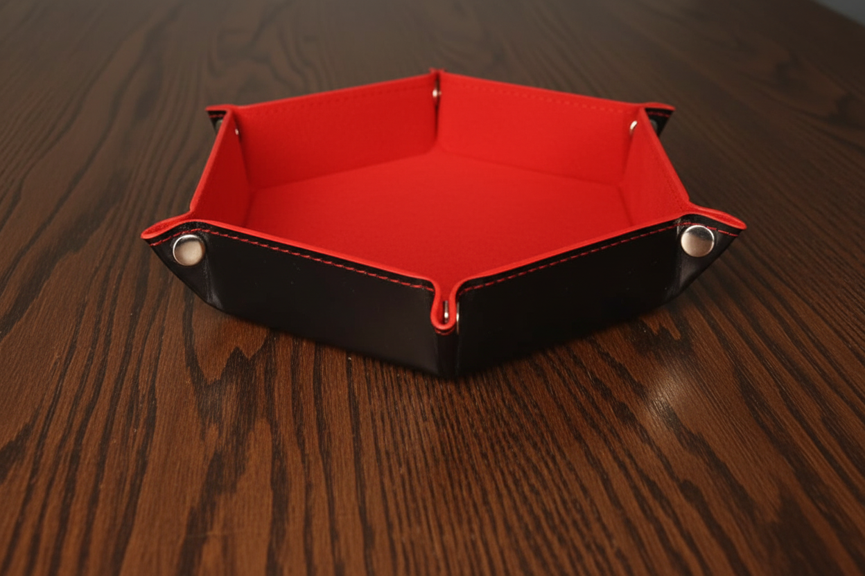 Red and black hexagonal dice tray on a dark oak table