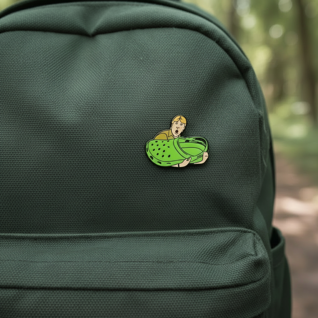 Enamel Pin of Steve Irwin Holding a Croc Shoe on a green backpack
