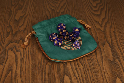 Teal dice bag with blue and gold dice on a  dark oak table