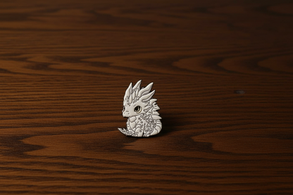 Silver dragon-shaped pin on a dark oak table