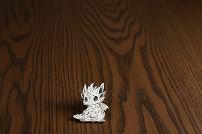 White Pointy Ear Dragon Pin Badge on a dark oak table